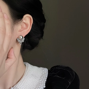 Detail of elegant silver stud earring with pearls and diamonds on a model