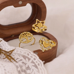 Set of 3 gold rings featuring star, tree of life, and heart designs with zircon stones