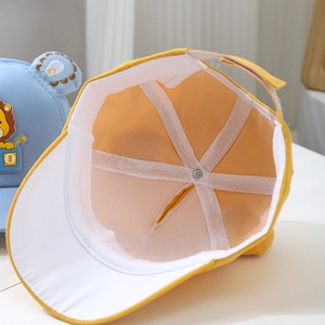 Detail showing breathable mesh interior and adjustable strap of yellow lion toddler cap