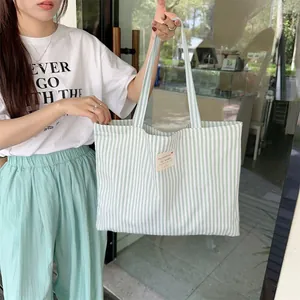 Detailed view of large capacity green and white striped canvas tote bag for daily commute