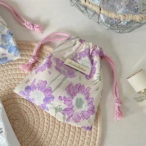 Dettaglio del sacchetto floreale con coulisse e stampa a fiori viola in cotone