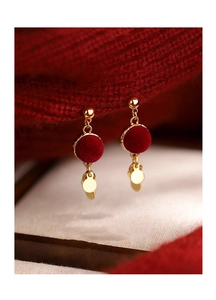 Close-up of red flocked round earrings with gold metallic sequins and soft winter texture