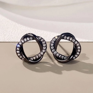 Close-up of gunmetal interlocking twisted hoop earrings with micro-paved zircons