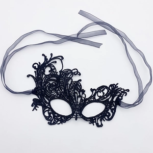 Detailed macro view of black lace eye mask with intricate floral vine patterns