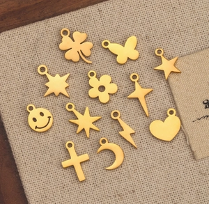 Flat lay of gold stainless steel charms in shapes of stars moon and heart for DIY jewelry
