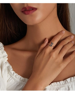 Detailed view of a vintage dragonfly open ring with blue enamel on a model's finger