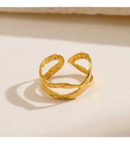 Macro detail of golden minimalist ring featuring unique liquid lava texture and open design