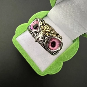 Close-up of retro owl ring with purple gem eyes in a green velvet jewelry box