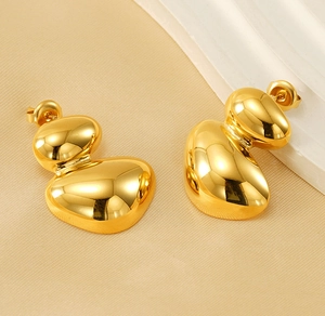 Close-up of golden irregular organic shaped stud earrings with a high polished finish