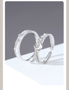 Macro shot of 925 silver couple rings featuring moon and star patterns with cubic zirconia