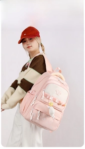 Detail of pink school backpack with cartoon prints and plush animal charm on side