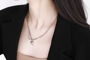 Primo piano dettagliato di una collana con ciondolo a cuore argento su una modella