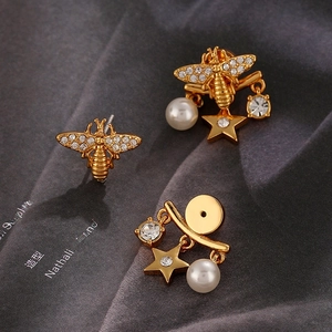 Luxury bee earrings with sparkling rhinestones and pearl drops on a satin background