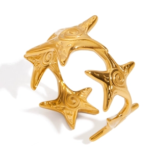 Macro shot of gold starfish open ring featuring detailed ocean-inspired design and metallic shine
