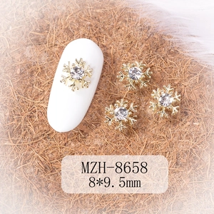 Macro view of gold snowflake nail art charm with crystal diamond and 8x9.5mm dimensions