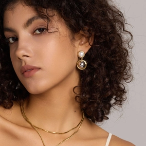 Elegant gold double layer pearl drop earrings on model with high quality metallic finish