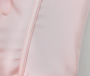 Gros plan sur le tissu élastique rose avec doubles coutures et petit anneau de suspension