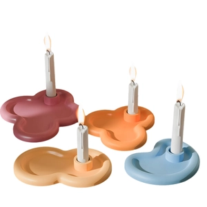 Minimalist cloud-shaped candle holders in four matte pastel colors with lit candles
