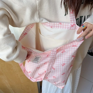 Detail view of pink plaid canvas tote bag showing interior lining and functional pocket