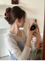 Close-up of a large red resin hair claw clip styled on wavy hair for an elegant look
