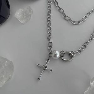 Detail of silver double-layered necklace with pearl and rhinestone cross pendant on crystal