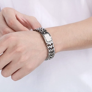 Gros plan d'un bracelet en acier titane argenté avec plaque rectangulaire personnalisable