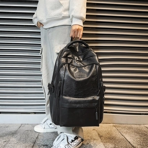 Large black PU leather backpack with front zipper pocket and adjustable straps for travel