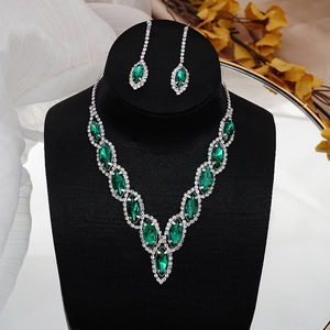 Macro shot of emerald green marquise crystals and silver diamond accents on bridal set