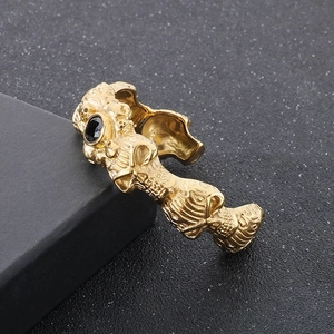 Macro shot of gold gothic skull bracelet with intricate floral relief and black zircon stone
