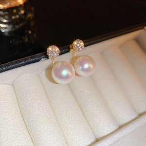 Macro view of 18k gold plated flower pearl stud earrings with crystal inlay in box
