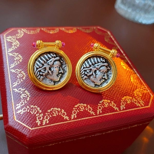 Macro view of vintage coin earrings with silver portrait relief and pink gemstones