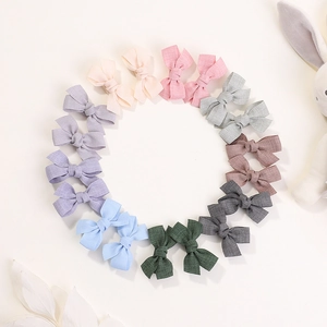 Set of colorful handmade fabric bow hair clips for kids arranged in a circular pattern