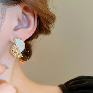 Close-up of vintage geometric gold plated earrings with mother of pearl and small rhinestones