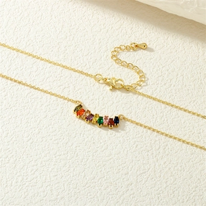 Detailed close-up of a gold necklace with colorful marquise-shaped zircon gemstones