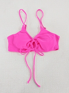 Detail of hot pink halter bikini top with ruched cutout and long decorative ties