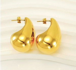 Macro detail of 18K gold plated teardrop earrings with a high-polished mirror finish