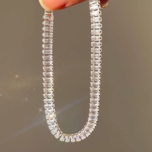 Macro shot of silver tennis necklace featuring rectangular cubic zirconia stones