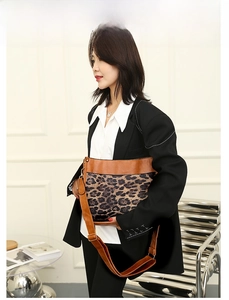 Detail of adjustable leather strap and buckle on a leopard print canvas tote bag
