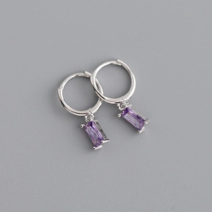 Detail of silver hoop earrings featuring rectangular purple gemstone pendants