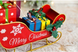 Detail of red metal Christmas sleigh with gift boxes and Merry Christmas lettering