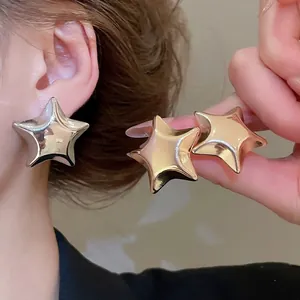 Stylish large chunky star-shaped stud earrings in polished gold and silver metal finishes