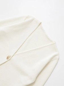 Close-up of premium knit cardigan featuring a V-neck and decorative gold metal button