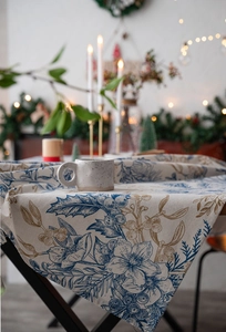 Close-up of pine branch floral print on cotton linen Christmas tablecloth with festive decor