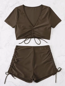Detail of chocolate brown two-piece bikini with V-neck cropped top and drawstring shorts