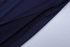 Détail d'une robe bleu marine avec fente latérale et coutures de qualité sur le tissu