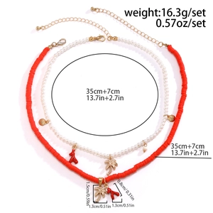 Detail of layered sun flower necklace featuring faux pearls and coral charms with specs