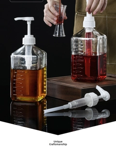 Detail view of graduated glass syrup bottles with white precision pump heads for cafe use