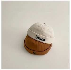 Vista dettagliata di due cappelli Miki impilati in beige e caramello con ricamo Unice