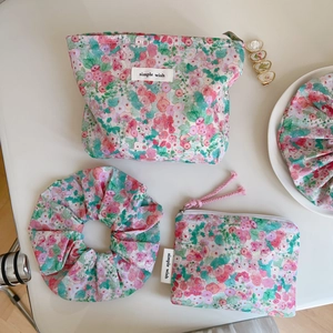 Close-up of floral cotton accessory set including makeup bag and matching hair scrunchie