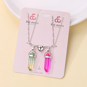 Detail of couple magnetic heart necklaces with green and purple crystal pendants